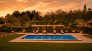 a pool in a yard with chairs and lights at Tourist Farm Ranč Velka in Spodnja Velka