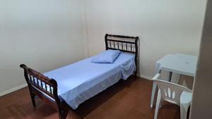 a small bedroom with a bed and a table at Hotel Pousada Angra Encanto in Angra dos Reis +7 photos