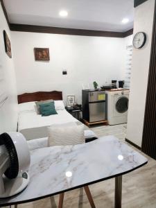 a room with a bed and a table and a microwave at Cozy Studio Rohrmoser in San José