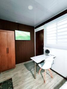 a room with a table and a television on the wall at Cozy Studio Rohrmoser in San José