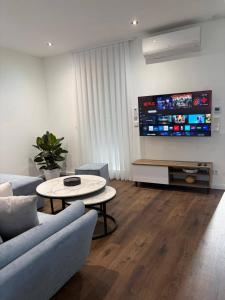 a living room with a couch and a table and a tv at Apartman Tomislav in Slavonski Brod
