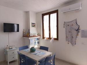 a dining room with a table and blue chairs at Il Mascone in Stintino
