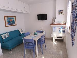 a living room with a blue couch and a table at Il Mascone in Stintino
