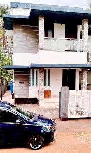 a black car parked in front of a house at Darshan Stay in Trichūr