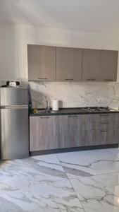 a kitchen with a stainless steel refrigerator and cabinets at Casa Jenny sul mare in Scalea +14 photos