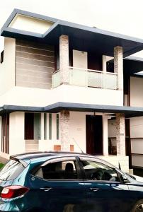 a car parked in front of a house at Darshan Stay in Trichūr