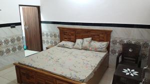 a bedroom with a bed with a wooden headboard at Vallabh Kunj Sewa Sadan in Govardhan