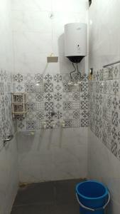a bathroom with a blue bucket in a room at Vallabh Kunj Sewa Sadan in Govardhan