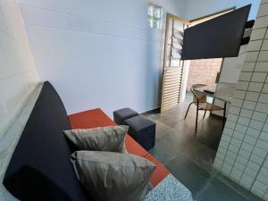 a living room with a couch and a table at Unidade 2 - GoHost Suítes in Ribeirão Preto