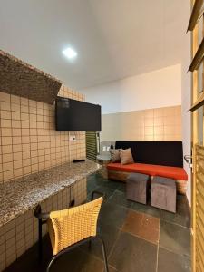 a living room with a couch in a room at Unidade 2 - GoHost Suítes in Ribeirão Preto