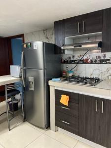 a kitchen with a stainless steel refrigerator and a table at Dalejadrohouse in Baños