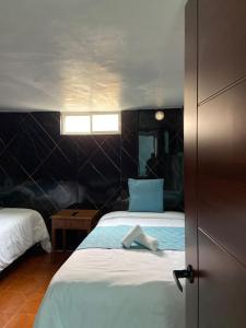 a bedroom with a bed with a towel on it at Dalejadrohouse in Baños +4 photos