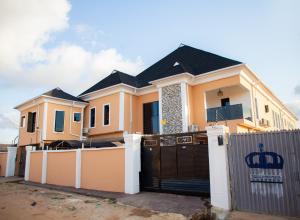 a house with a fence in front of it at Radores Apartment in Ayobo