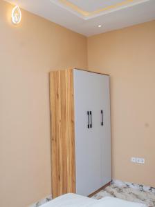 a bedroom with a white cabinet in the corner at Radores Apartment in Ayobo
