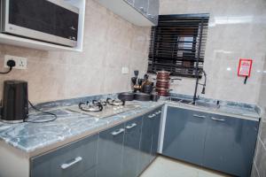 a kitchen with blue cabinets and a counter top at Radores Apartment in Ayobo