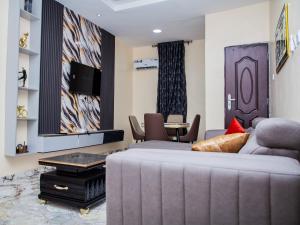a living room with a couch and a table at Radores Apartment in Ayobo