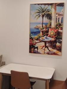 ein Gemälde von einem Tisch und Stühlen an einer Wand in der Unterkunft سكوت Scoott in Dschāzān