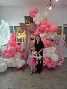 a woman and a little girl standing in front of a bunch of balloons at Paunasul Codrilor in Câmpulung Moldovenesc