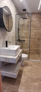 a bathroom with a sink and a shower at 5 Suites Αγιόκαμπος Αγίας in Agiokampos