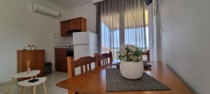 a kitchen and dining room with a table and a refrigerator at 5 Suites Αγιόκαμπος Αγίας in Agiokampos +11 photos