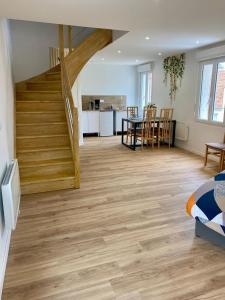 a living room with a staircase and a dining room at Jasmin in Saint-Aignan