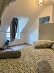 a attic bedroom with a bed and a ceiling at Jasmin in Saint-Aignan