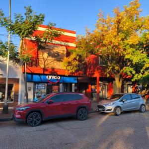 two cars parked on a street in front of a store at Alojamiento Tía Silvia in San José