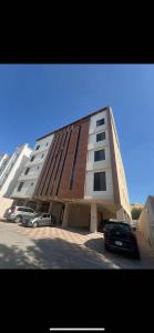 a large building with cars parked in a parking lot at أستديو حديث عصري in Ath Thuqbah