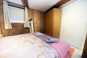 a bedroom with a large bed with two towels on it at Rustic 2BR Loft Exposed Brick & Beams in Liverpool +4 photos
