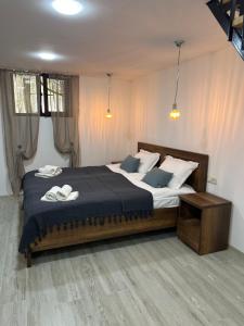 a bedroom with a large bed with two towels on it at Duplex Vakhrama in Abastumani
