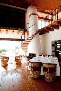a dining room with tables and a spiral staircase at Misión Grand Casa Colorada in Guanajuato