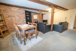 a dining room with a table and chairs and a brick wall at Rustic 2BR Loft Exposed Brick & Beams in Liverpool