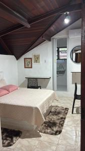 a bedroom with a bed and a table and chairs at Chalé Rochat Maresias in Maresias