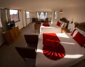 a hotel room with two beds with red pillows at Misión Grand Casa Colorada in Guanajuato
