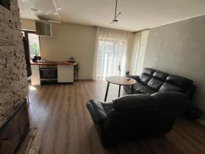 a living room with a leather couch and a table at Bebro namai in Vilnius