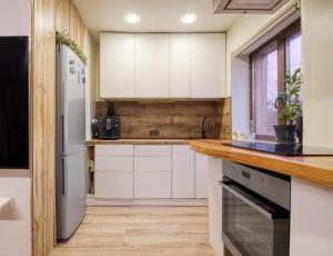 a kitchen with white cabinets and a refrigerator at Bebro namai in Vilnius