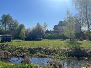 a field with a house in the background at Bebro namai in Vilnius