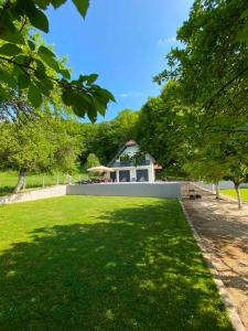 a garden with a house in the background at Kuca za odmor Moj Mir in Kalesija