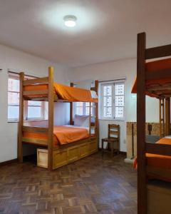 a bedroom with two bunk beds and a chair at York Hostel in La Paz