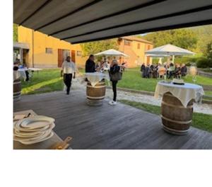 a group of people walking down a patio with tables and umbrellas at Agriturismo Accipicchia in Ancona