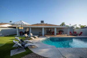 a house with a swimming pool and chairs in the yard at Scottsdale Osborn in Scottsdale