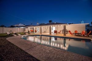 a swimming pool in front of a house at night at Scottsdale Osborn in Scottsdale