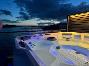a jacuzzi tub on a yacht at night at OceanView Karmoy Jacuzzi, Sauna & Sea Views in Karmøy