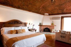 a bedroom with a large bed and a fireplace at Misión Grand Casa Colorada in Guanajuato