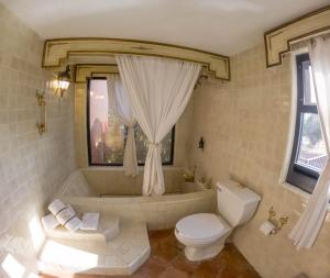 a bathroom with a tub and a toilet and a sink at Misión Grand Casa Colorada in Guanajuato +29 photos