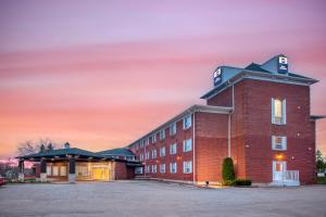 a red brick building with a sunset in the background at Best Western Kincardine in Kincardine
