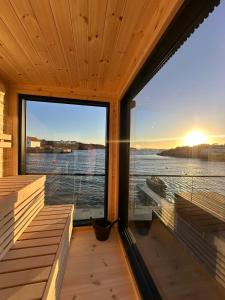 a room with a large window with a view of the water at OceanView Karmoy Jacuzzi, Sauna & Sea Views in Karmøy