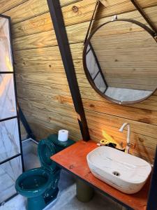 a bathroom with a sink and a toilet and a mirror at Alpine Cabin PR 2026 in Tavera Abajo