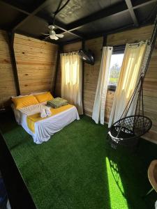 a bedroom with a bed in a room with green carpet at Alpine Cabin PR 2026 in Tavera Abajo
