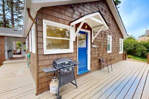 a house with a grill on a wooden deck at 2nd Tee at Neskowin Village in Neskowin